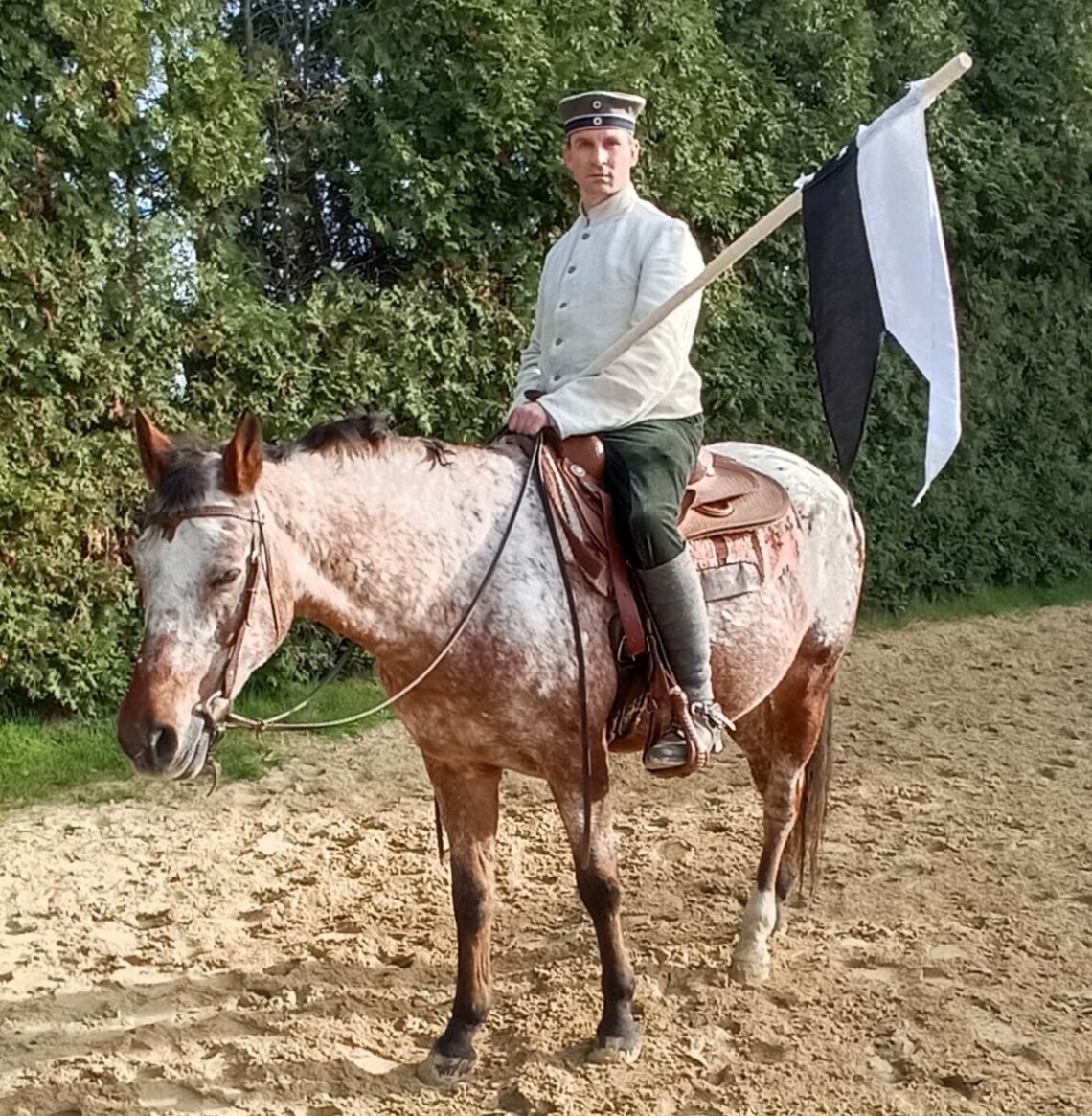 Mit Lanze in hist. Trainingsuniform auf Pferd sitzend